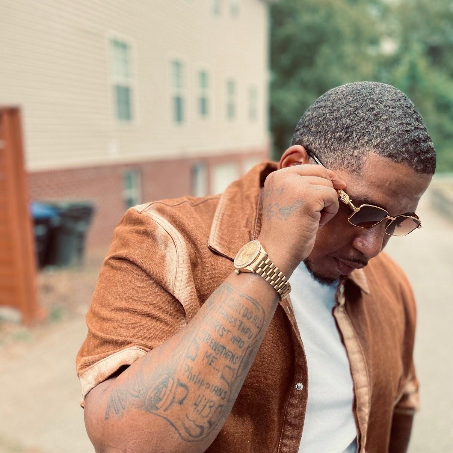 Sinatris outdoors in Chicago wearing a brown jacket and sunglasses